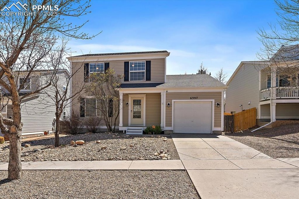 Traditional-style home with an attached garage, fence, and driveway