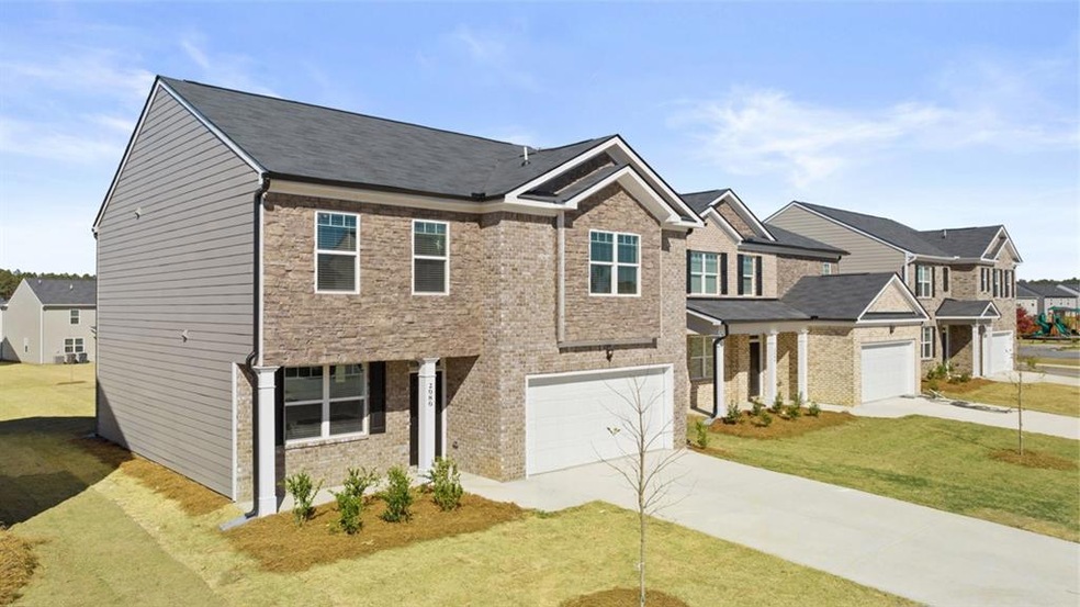 View of front of property featuring a garage and a front lawn