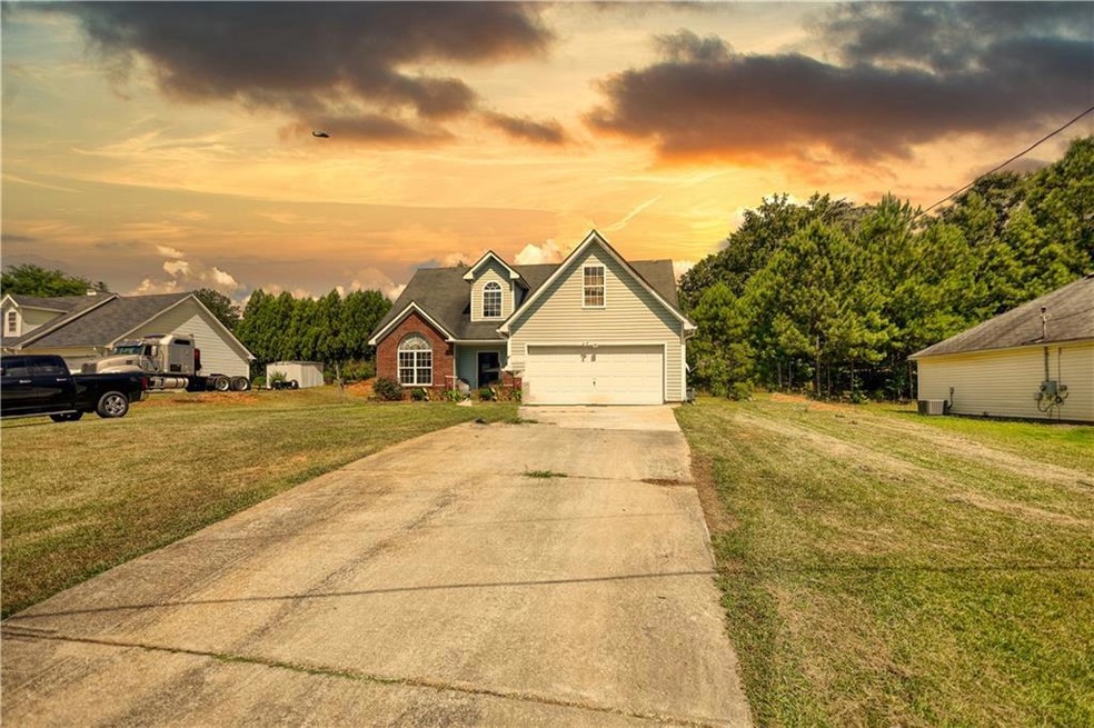 Traditional home featuring a garage, driveway, and a lawn