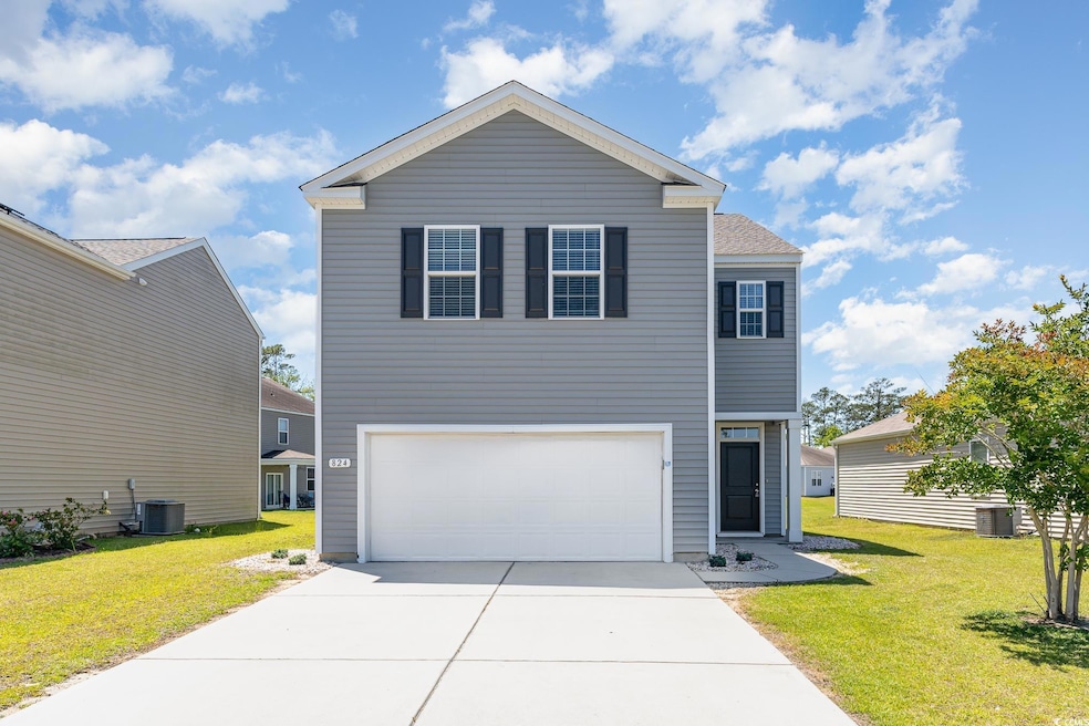 View of front of house featuring driveway, an attached garage, and a front yard