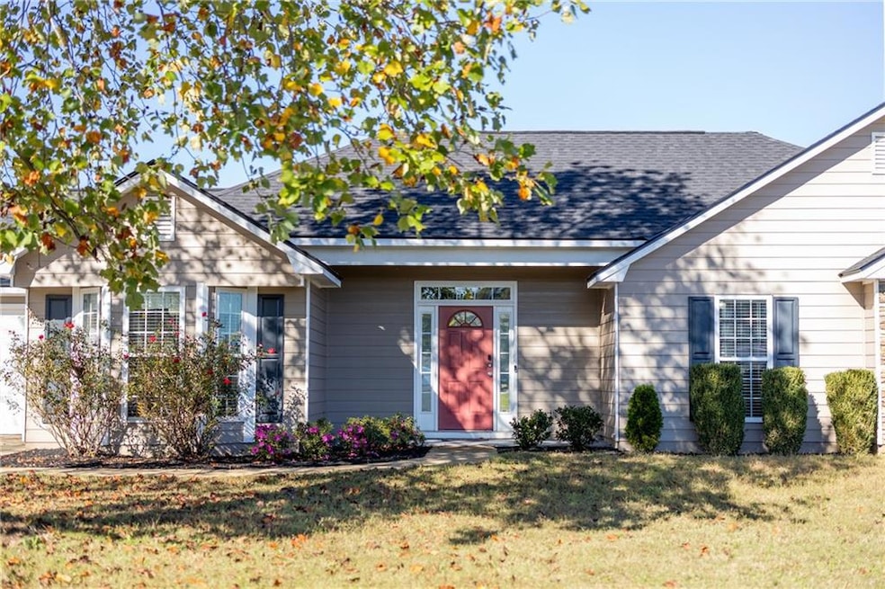 Ranch-style home featuring a front yard and a gara