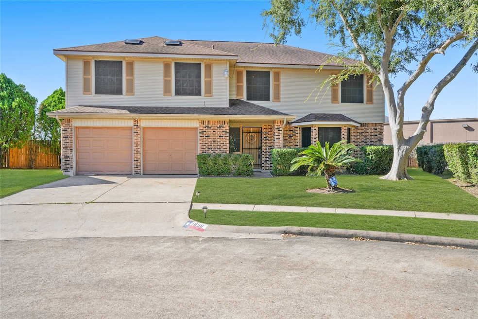 This is a two-story brick home featuring a double garage, neatly manicured lawn, and mature trees. The property offers a spacious driveway and well-maintained landscaping, providing great curb appeal.