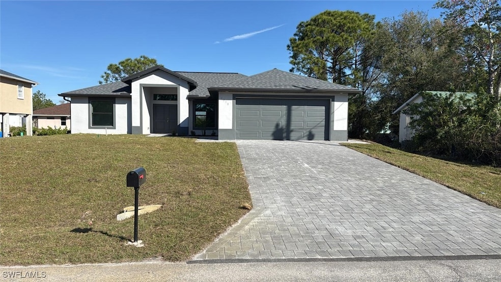 View of front of house with decorative driveway, a