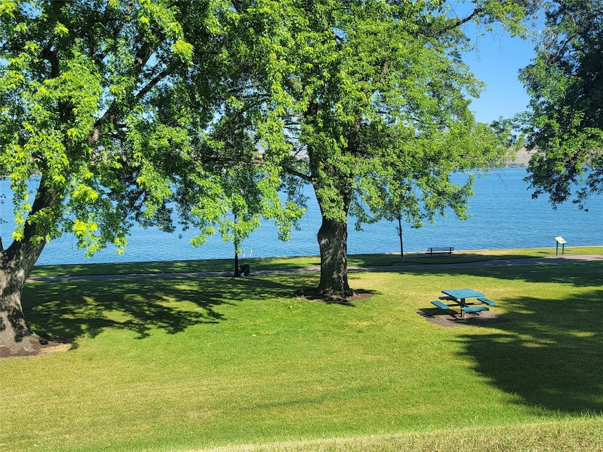 Surrounding community with a lawn and a water view
