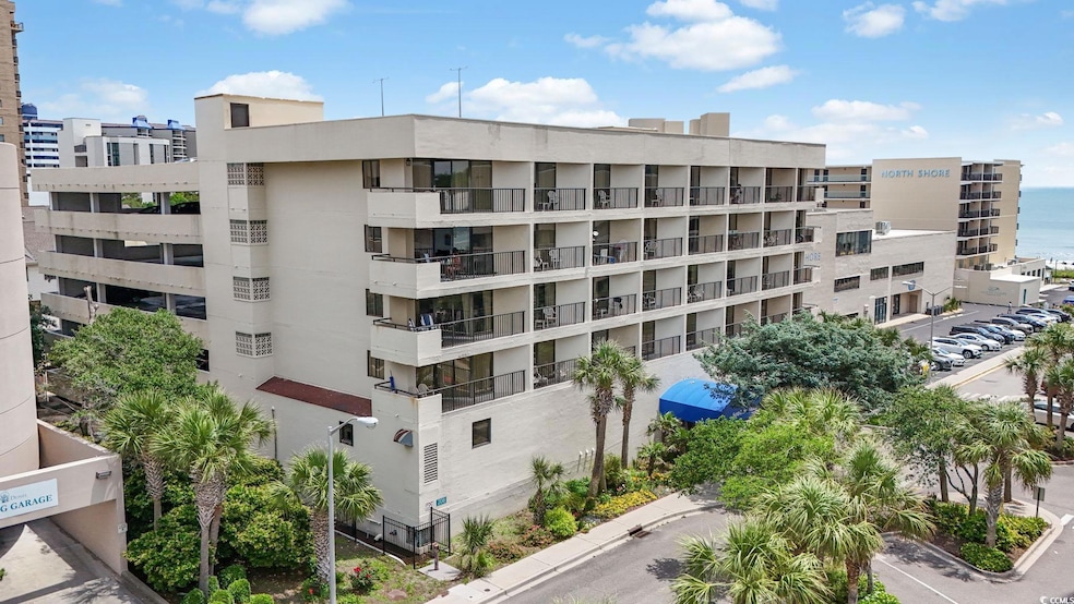 View of apartment building / complex with uncovered parking