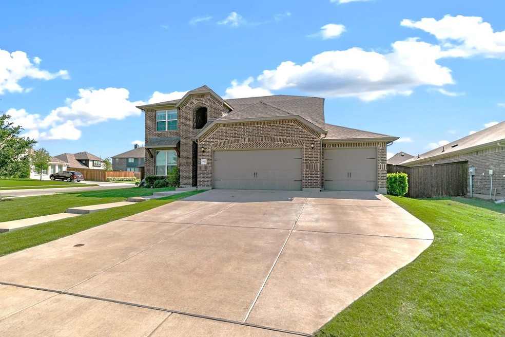 View of front facade featuring a garage and a front lawn