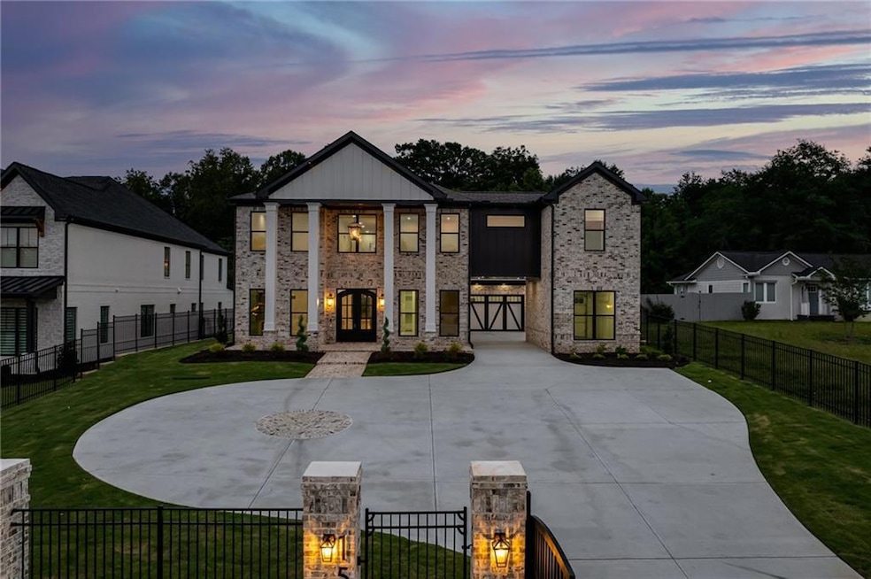 View of front facade featuring a gate, a fenced front yard, driveway, and brick siding