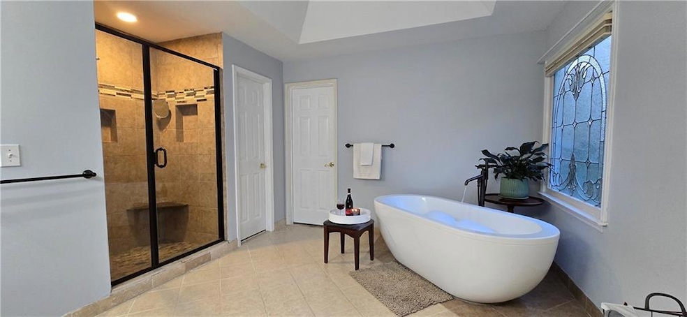 Bathroom featuring a freestanding bath, a shower stall, and tile patterned floors