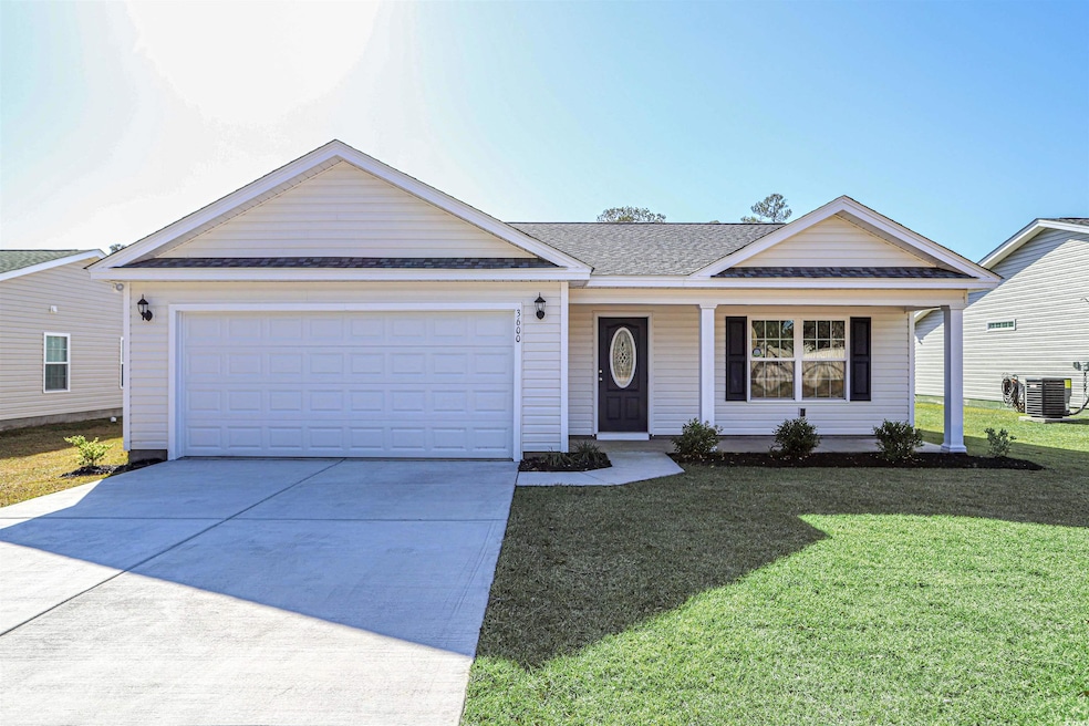 Ranch-style house with a shingled roof, concrete driveway, a front lawn, a garage, and a porch