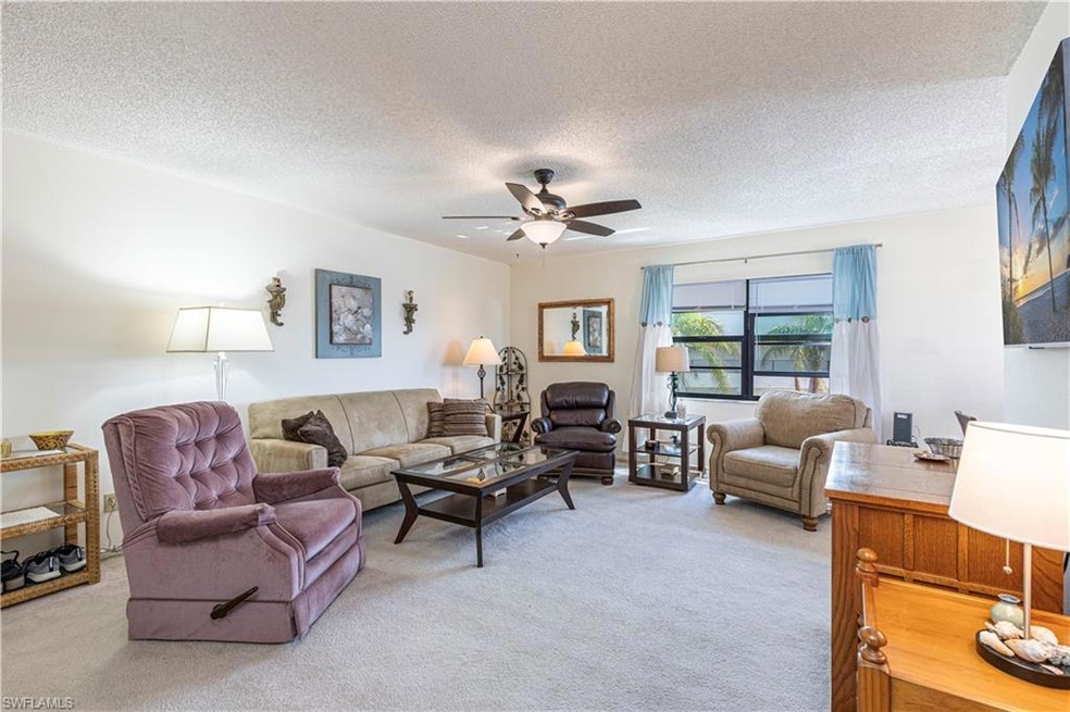 Living room with a textured ceiling, light colored