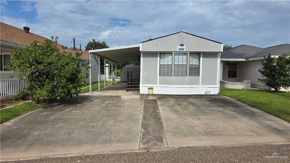 Manufactured / mobile home featuring driveway and an attached carport