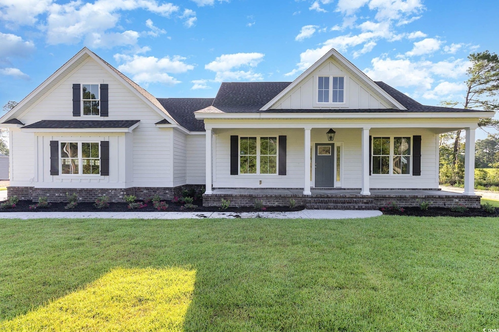 View of front facade with a front lawn and covered
