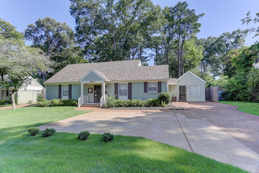 View of front of home with a front lawn, roof with shingles, and concrete driveway