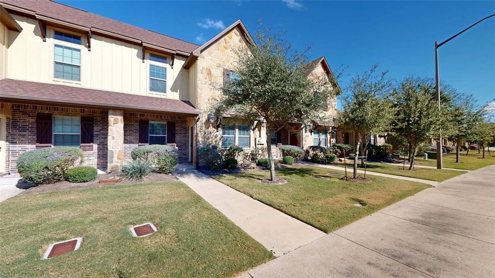 Traditional-style house with stone siding, a front yard, and roof with shingles
