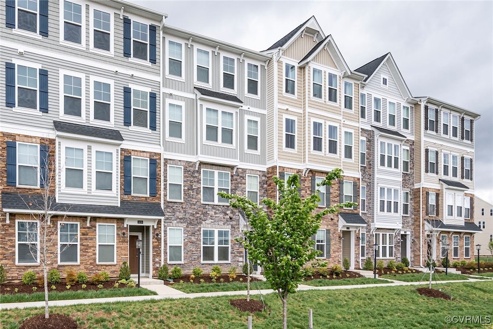 Multi unit property featuring a front lawn, stone