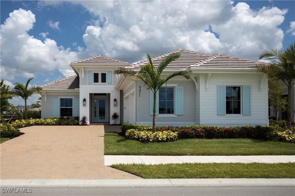 View of front of home with a tile roof and a front lawn