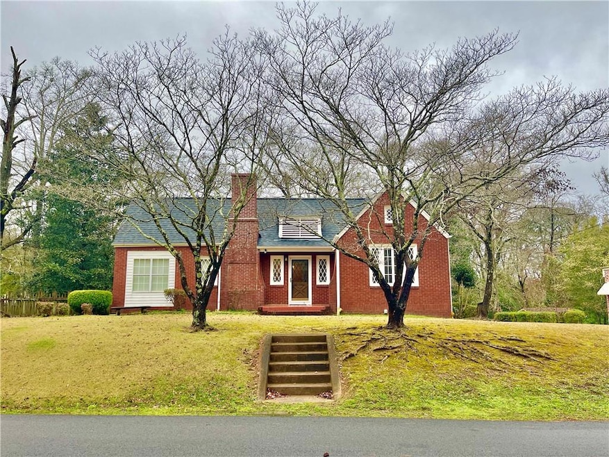 Tudor house featuring a front lawn, a chimney, and
