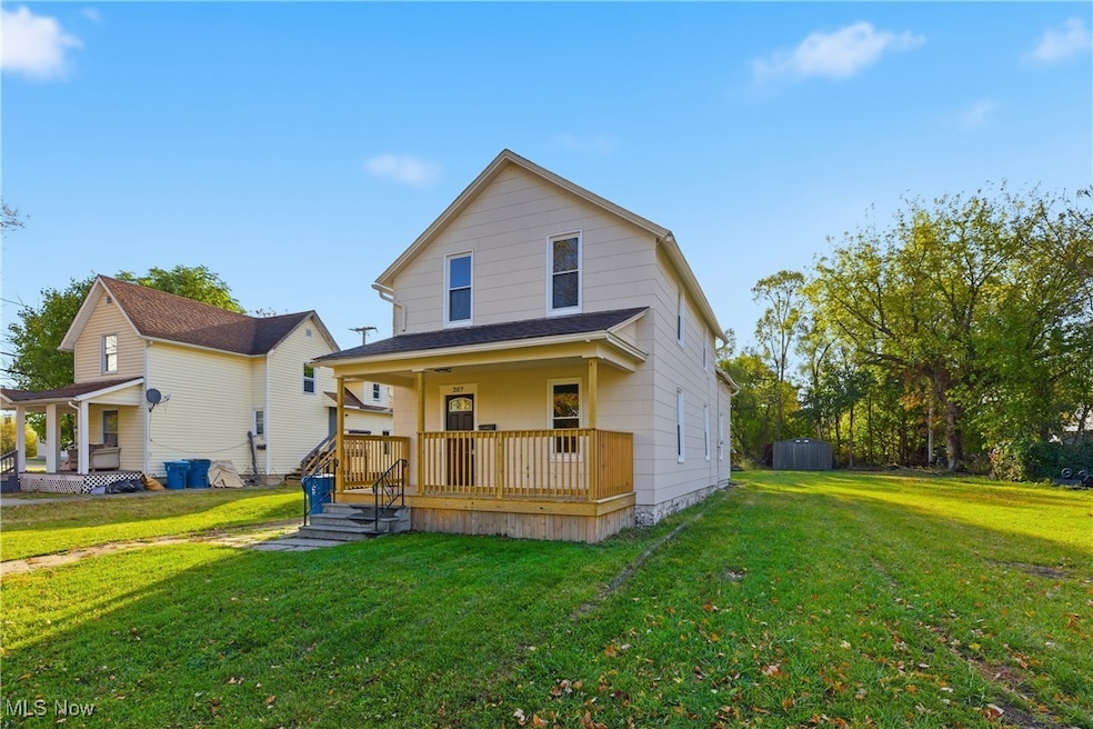 Rear view of house featuring a yard and a porch