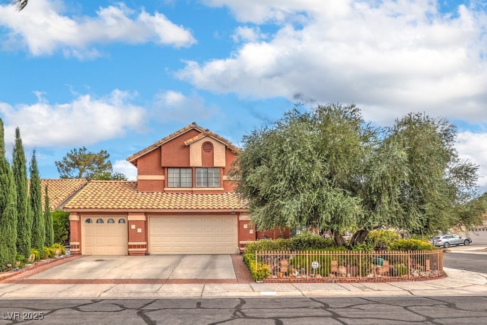 View of front of property featuring driveway, a tiled roof, stucco siding, and a garage