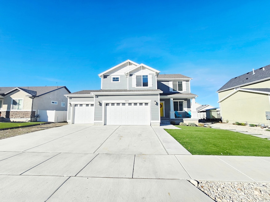 View of front of house featuring a front yard, concrete driveway, and an attached garage