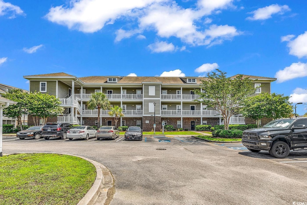 View of apartment building / complex featuring uncovered parking