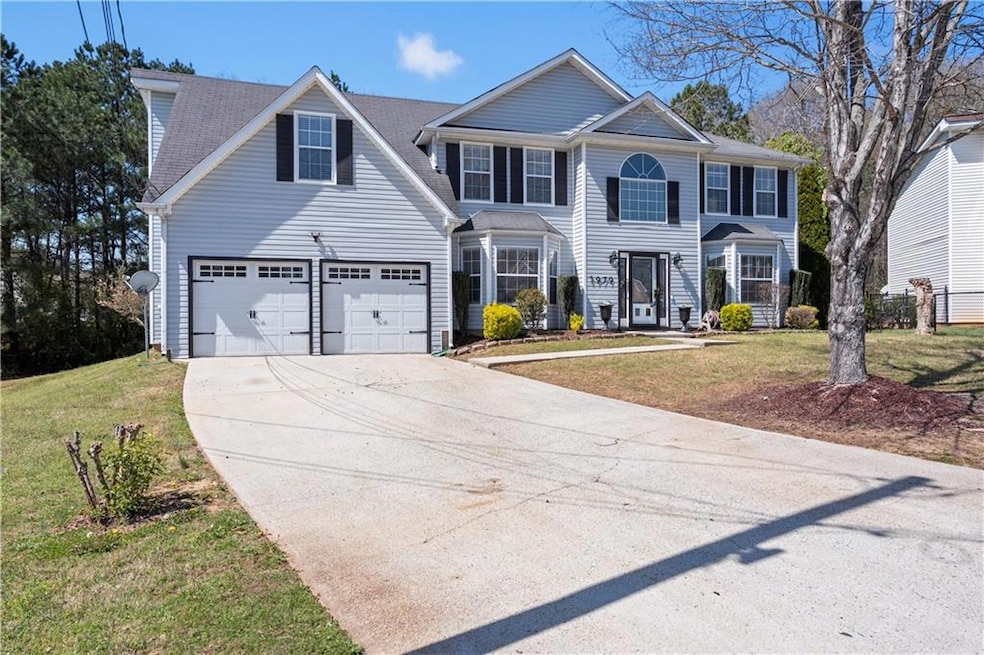 Colonial home with a front lawn, a garage, and dri