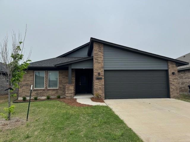 View of front of house with a front yard and a gar