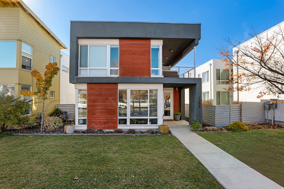 Back of house with a balcony and stucco siding