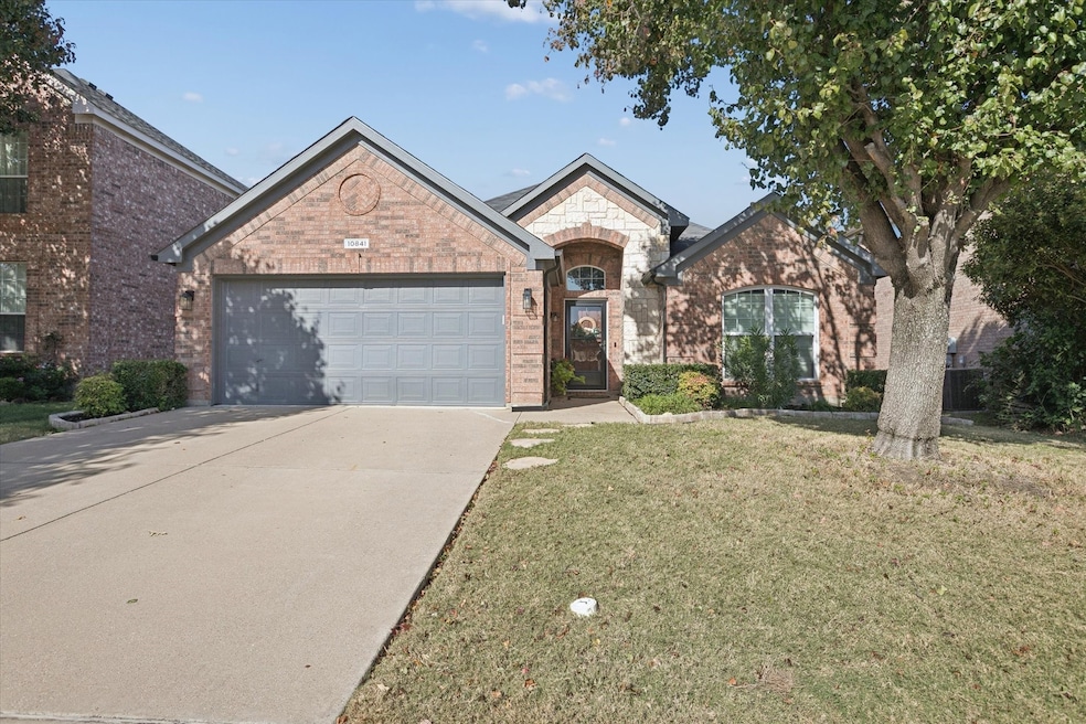French provincial home with brick siding, driveway, a front yard, and a garage
