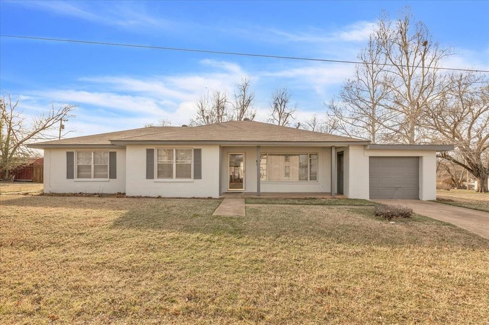 Ranch-style home with a front lawn and a garage