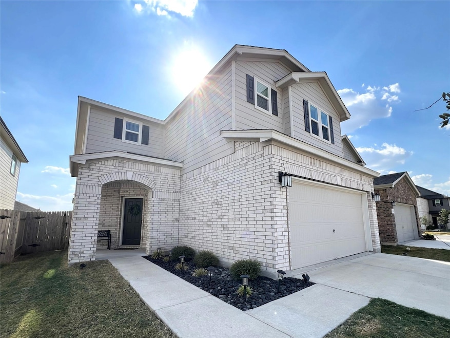 Traditional-style home featuring brick siding, concrete driveway, and a garage