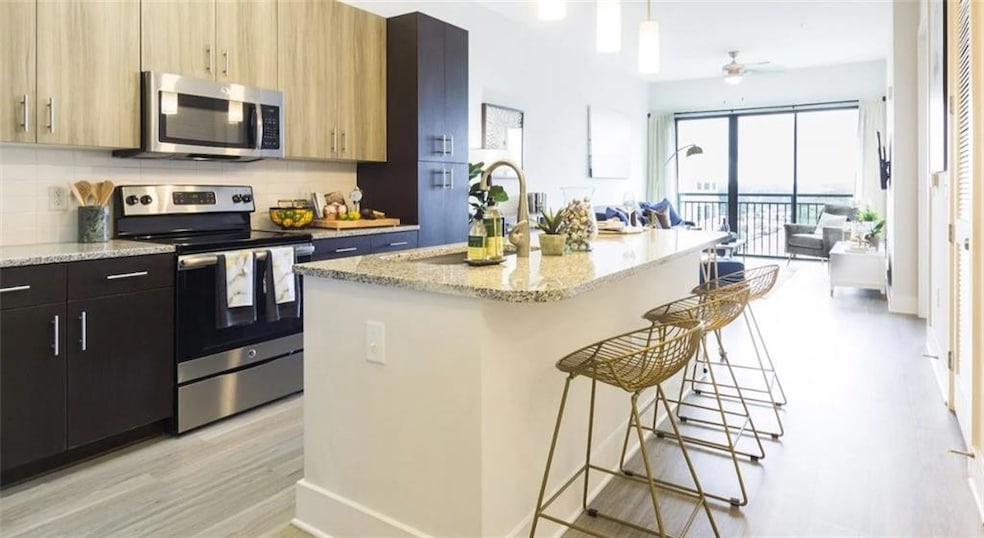 Kitchen featuring a kitchen bar, backsplash, appli