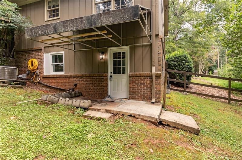 Property entrance with brick siding and board and batten siding