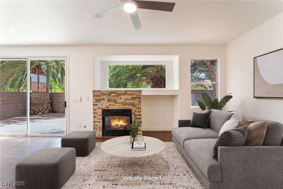 Living area with a fireplace and a ceiling fan