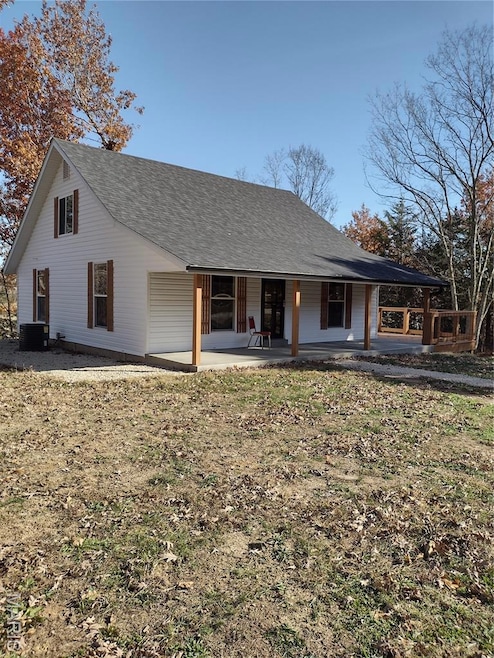 View of front of home featuring covered porch and a shingled roof