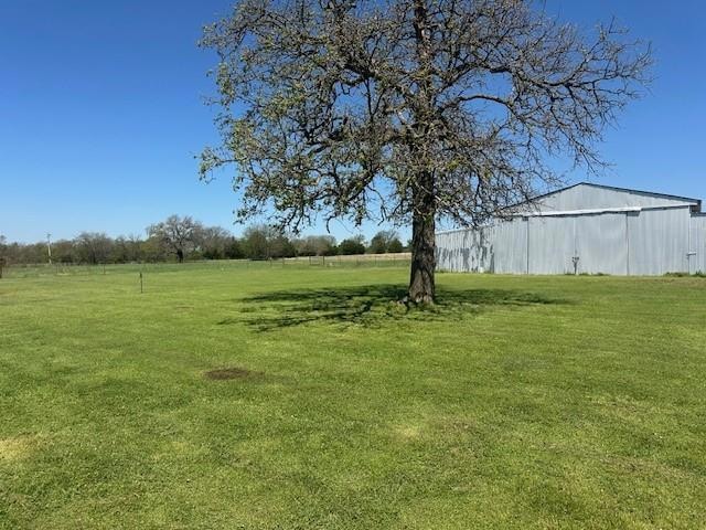 View of green lawn featuring barn and an outbuilding