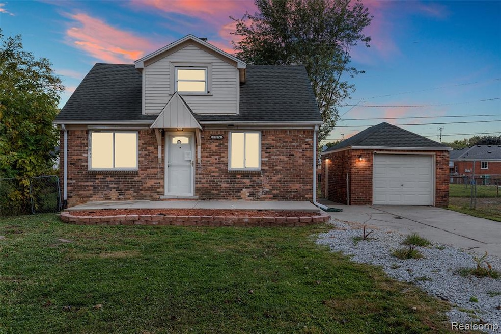 View of front of home featuring brick siding, driveway, the Garage, and a patio area
