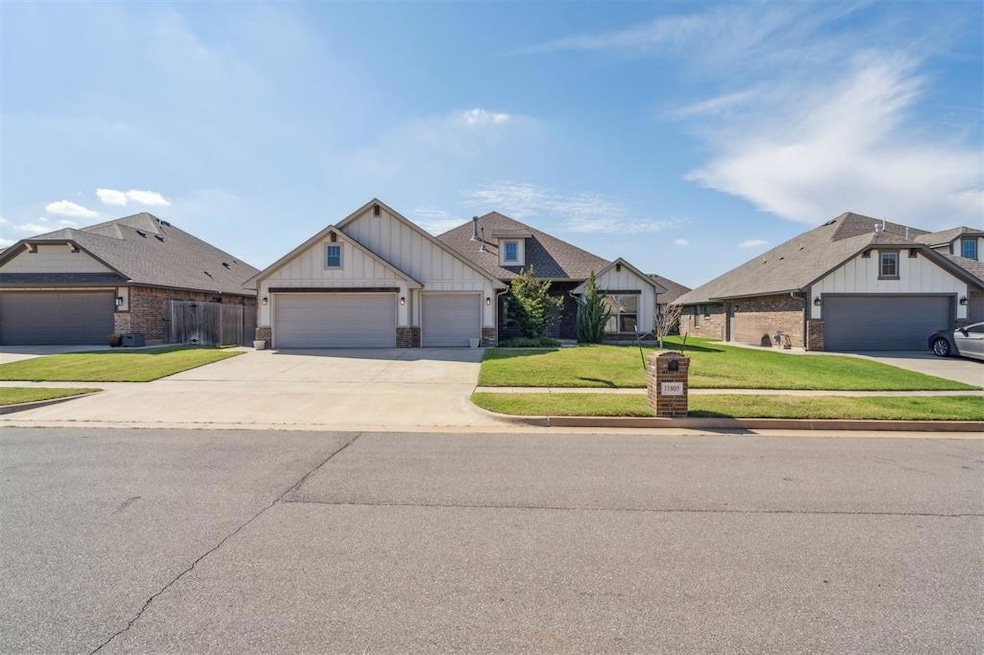 View of front of property featuring board and batten siding, a front lawn, driveway, and a garage
