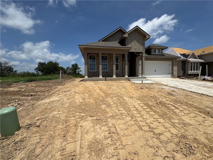 View of front of property featuring driveway, bric
