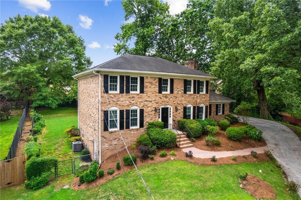 View of front of home with a chimney, brick siding, and driveway