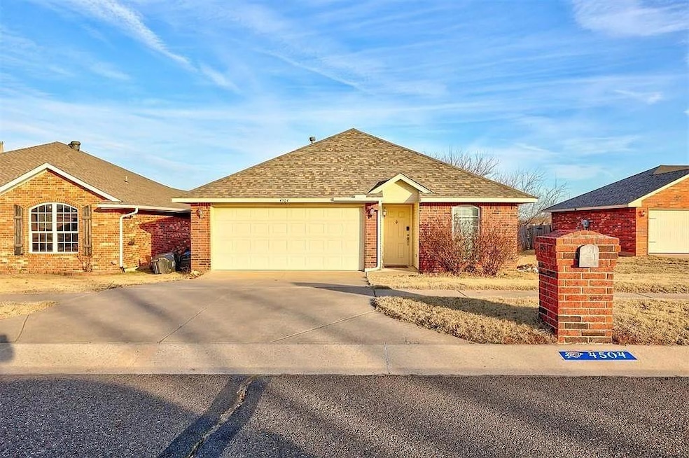 Single story home with driveway, brick siding, an attached garage, and roof with shingles