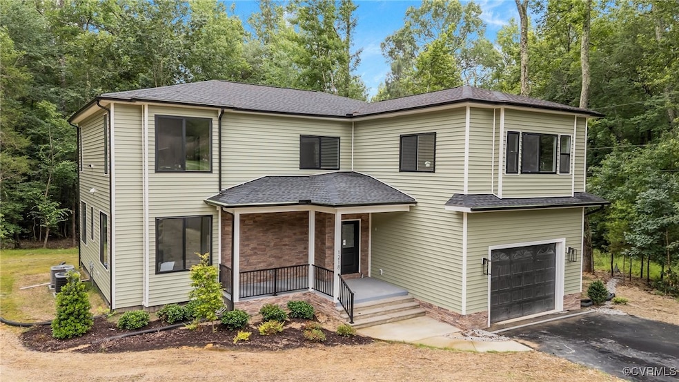 View of front facade with a porch, a garage, drive