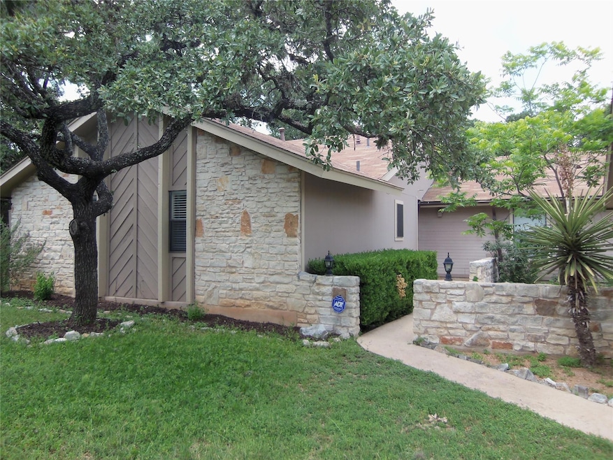 View of home's exterior with stone siding, a yard