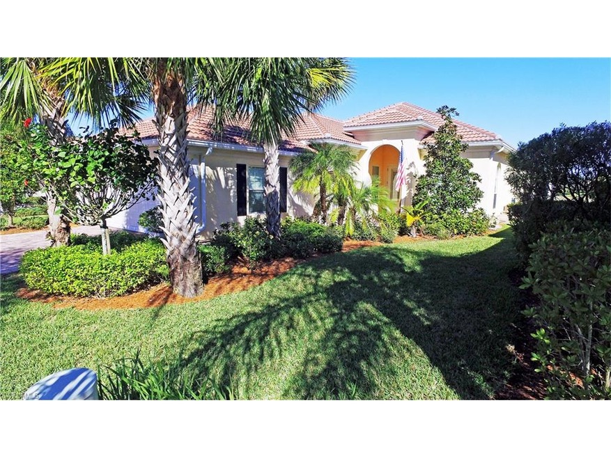 Inviting entry with paver brick driveway and mature landscaping.