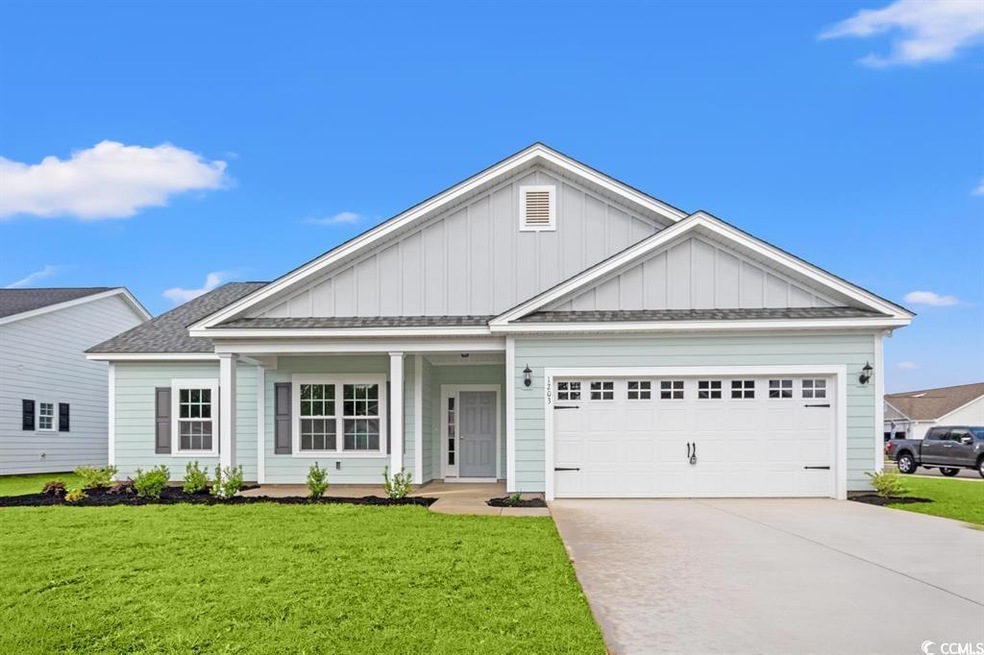 View of front facade featuring board and batten siding, a front lawn, and driveway