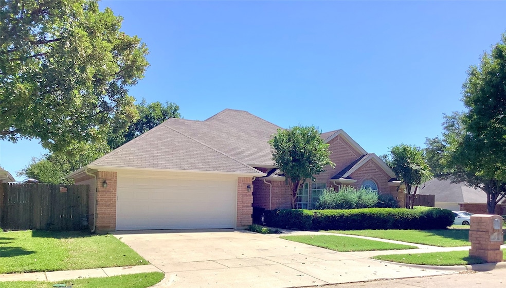 Single story home featuring concrete driveway, brick siding, an attached garage, and roof with shingles