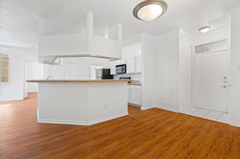 Kitchen with freestanding refrigerator, light woo