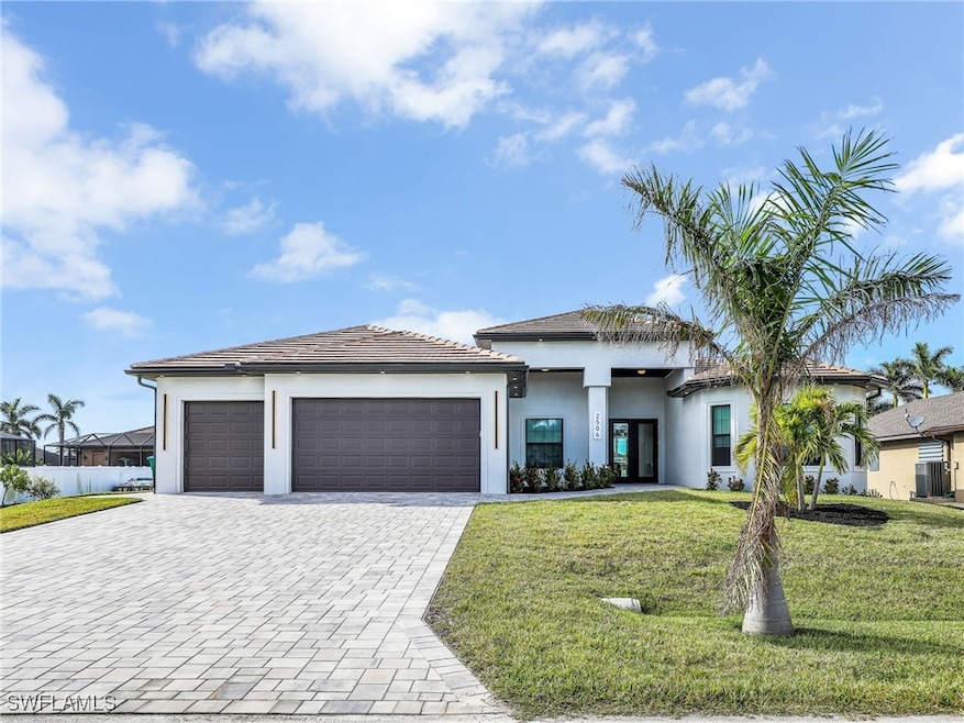 Prairie-style home with a garage, decorative driveway, stucco siding, and a tiled roof