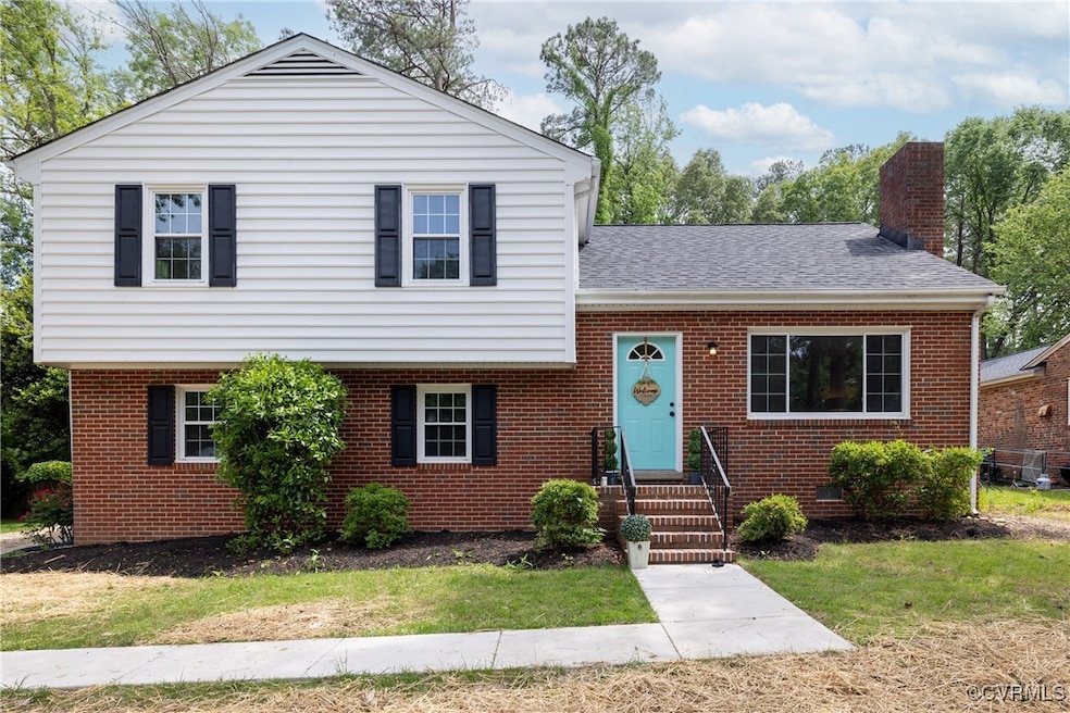 Split level home with brick siding, a chimney, a f