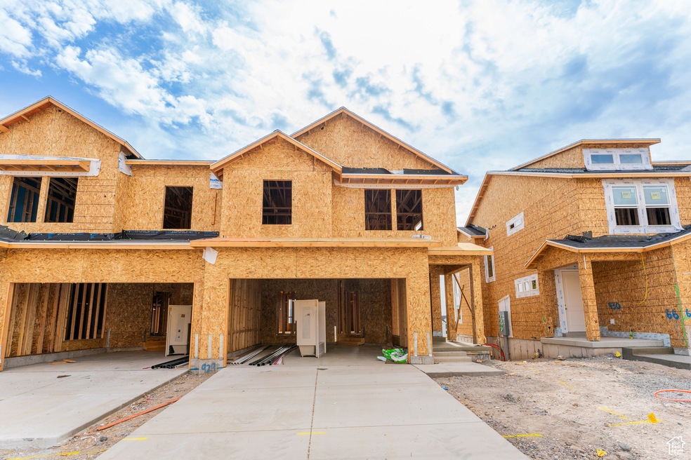 Property in mid-construction with driveway and an attached garage